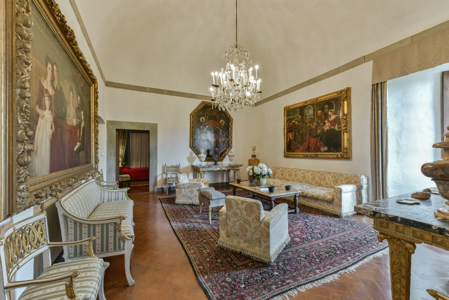 Luxurious living room featuring ornate furniture, vintage paintings, and a chandelier, showcasing classic interior design elements and rich textures. | Only on SopranoVillas