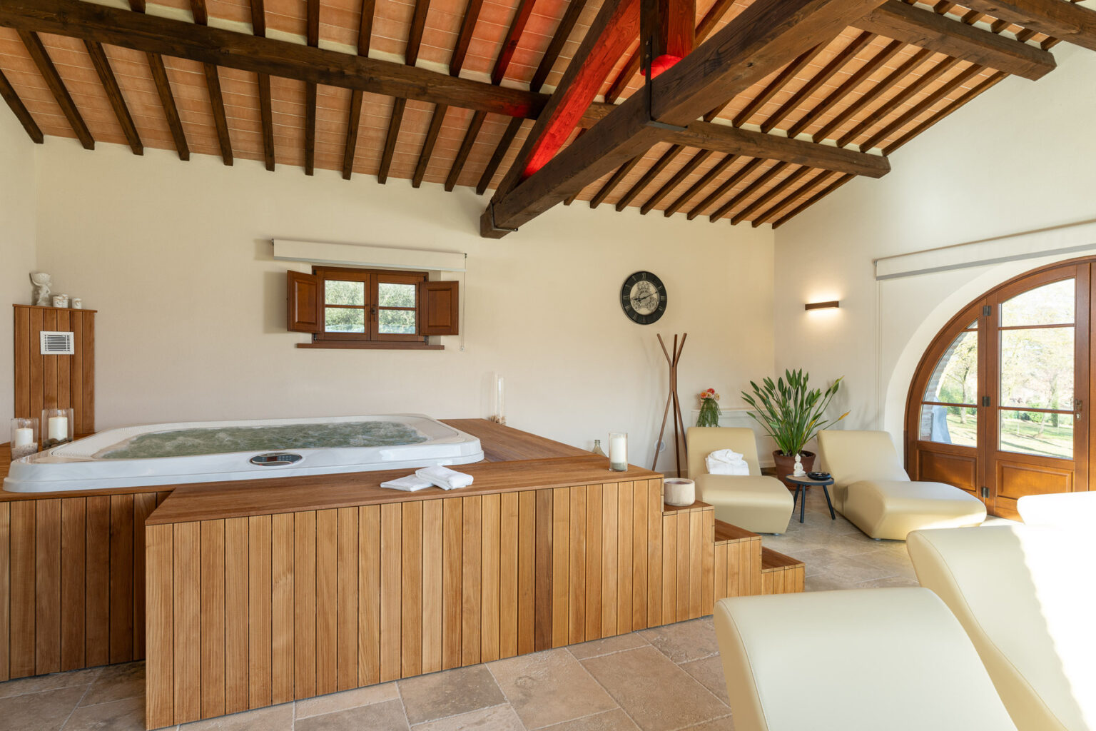 Luxurious spa interior featuring a wooden hot tub, comfortable seating, and rustic wooden beams, creating a relaxing atmosphere for wellness and relaxation. | Only on SopranoVillas
