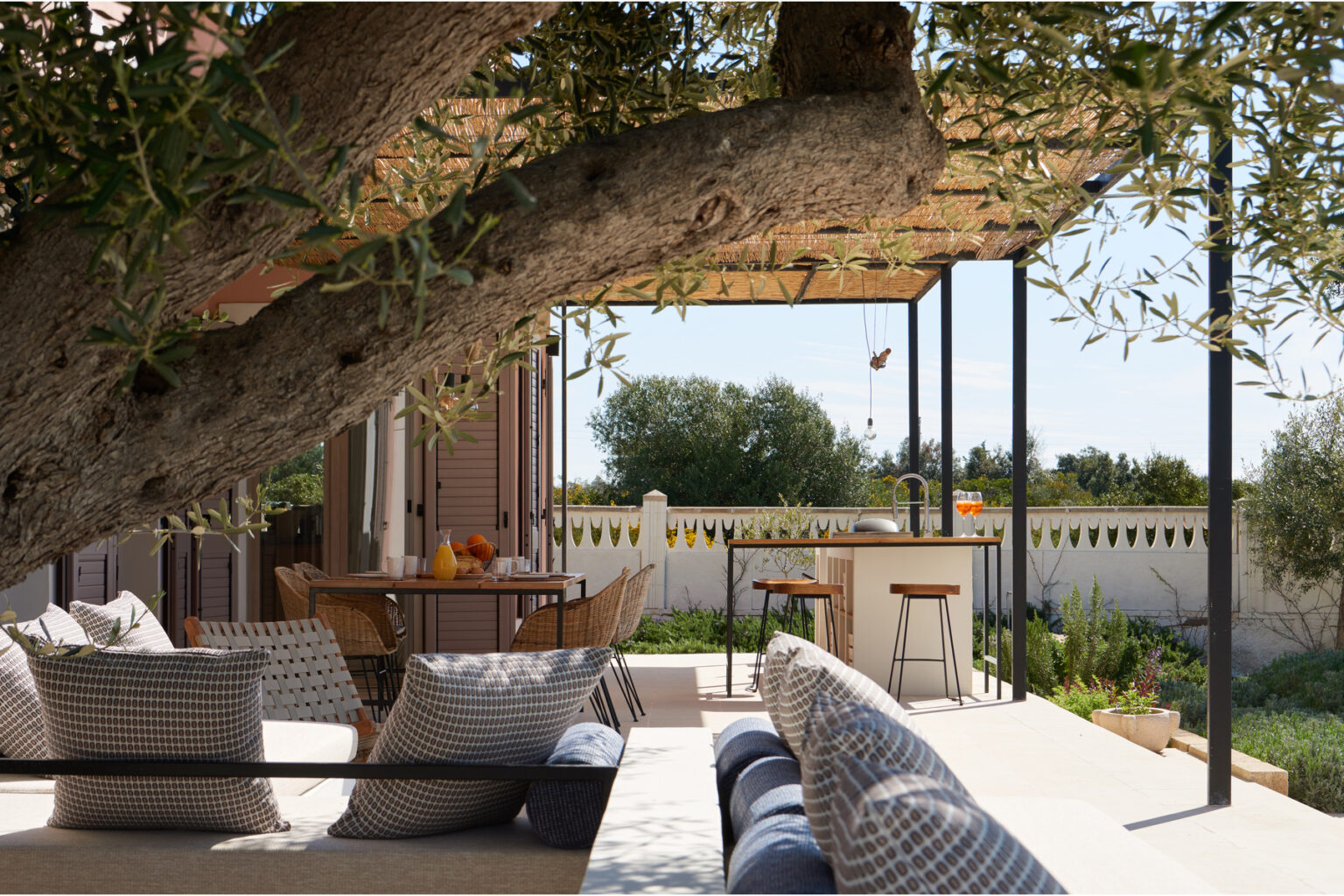 Cozy outdoor patio featuring comfortable seating, a shaded area under a pergola, and views of a lush garden, perfect for relaxation and entertaining. | Only on SopranoVillas