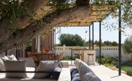 Cozy outdoor patio featuring comfortable seating, a shaded area under a pergola, and views of a lush garden, perfect for relaxation and entertaining.