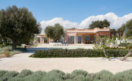 Modern villa with a pool surrounded by landscaped gardens, featuring olive trees and a sandy pathway, under a clear blue sky. Ideal for relaxation and outdoor living.