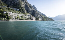 Scenic view of a lakeside resort with mountains in the background, showcasing clear blue water and lush greenery along the shoreline.