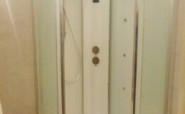 Shower enclosure featuring a glass door, control panel, and showerhead, designed for modern bathrooms.