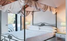 Elegant canopy bed in a modern bedroom with soft linens, natural light, and stylish bedside lamps, creating a serene and inviting atmosphere.