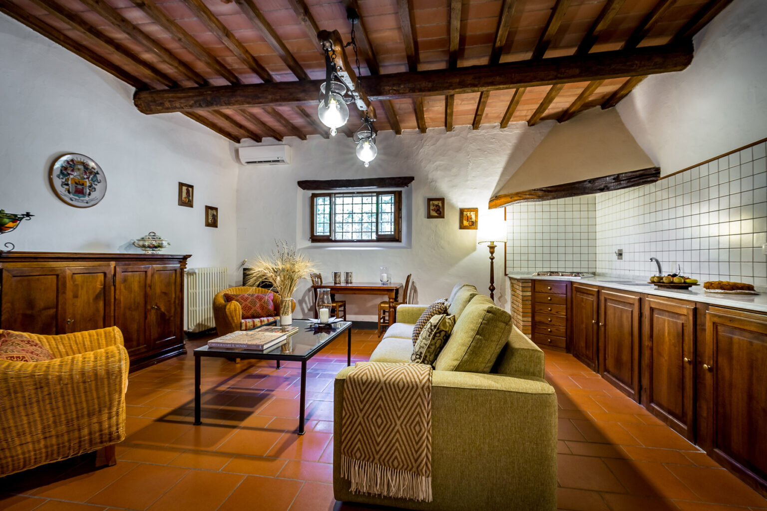 Cozy living room featuring rustic wooden beams, comfortable seating, and a functional kitchen area, perfect for relaxation and entertaining. | Only on SopranoVillas