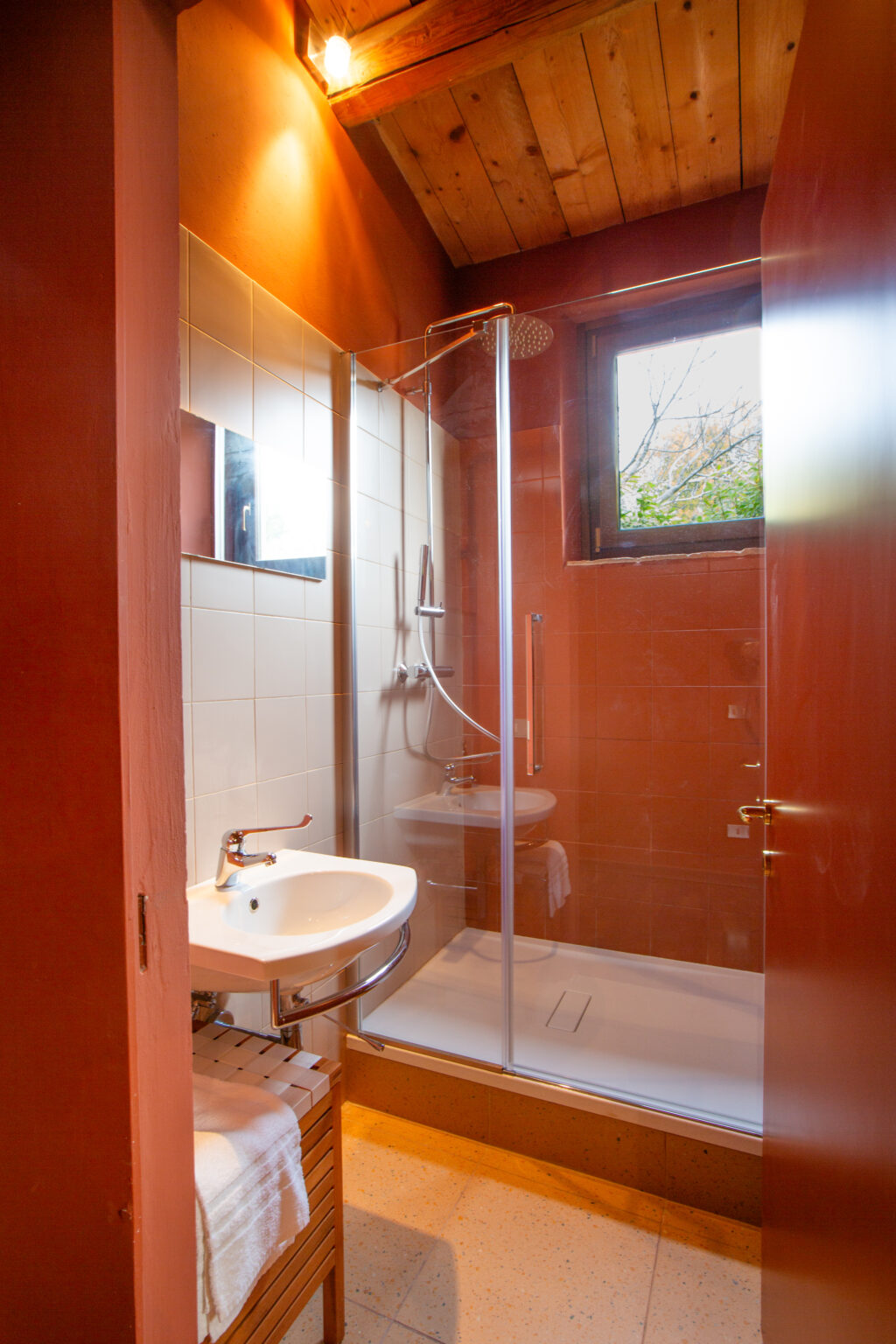 Modern bathroom featuring a glass shower enclosure, a white sink, and natural light from a window, showcasing a clean and functional design. | Only on SopranoVillas