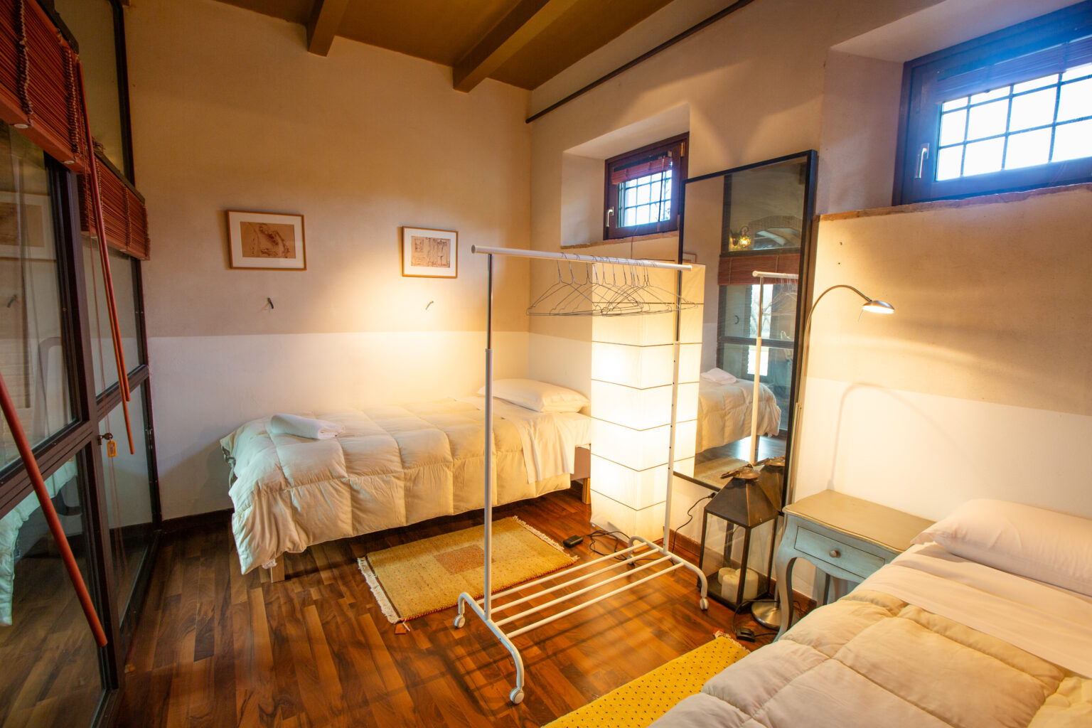 Cozy and inviting interior of a wellness room featuring two beds, natural wooden flooring, soft lighting, and decorative wall art, ideal for relaxation and rejuvenation. | Only on SopranoVillas