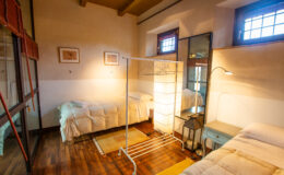 Cozy and inviting interior of a wellness room featuring two beds, natural wooden flooring, soft lighting, and decorative wall art, ideal for relaxation and rejuvenation.