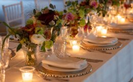 Elegant dining table set for a special occasion, featuring lush floral arrangements, crystal glassware, and soft candlelight, creating a warm and inviting atmosphere.