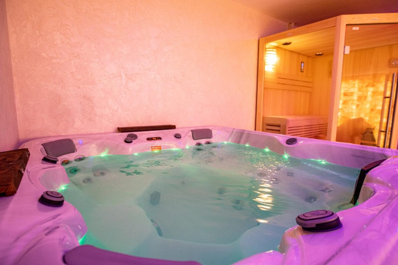 Luxurious indoor hot tub with soft lighting, surrounded by a relaxing atmosphere, featuring comfortable seating and a nearby sauna for ultimate relaxation. | Only on SopranoVillas