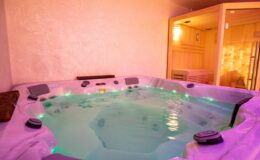 Luxurious indoor hot tub with soft lighting, surrounded by a relaxing atmosphere, featuring comfortable seating and a nearby sauna for ultimate relaxation.
