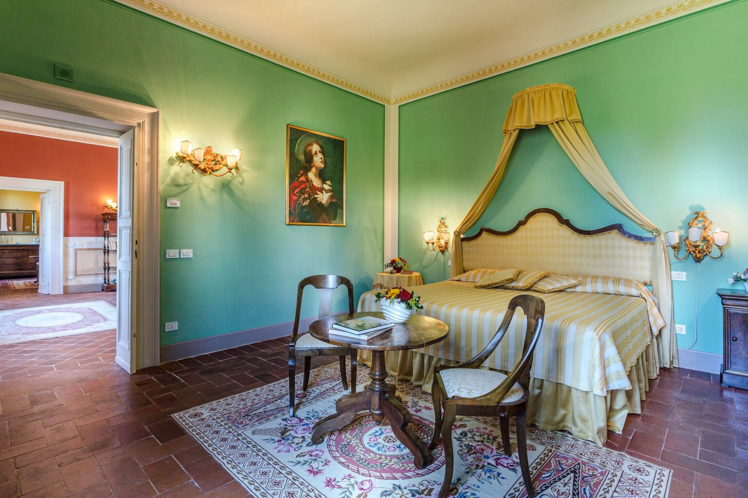 Elegant bedroom featuring a green color scheme, a queen-sized bed with a decorative canopy, antique wooden furniture, and soft lighting, creating a luxurious and inviting atmosphere. | Only on SopranoVillas