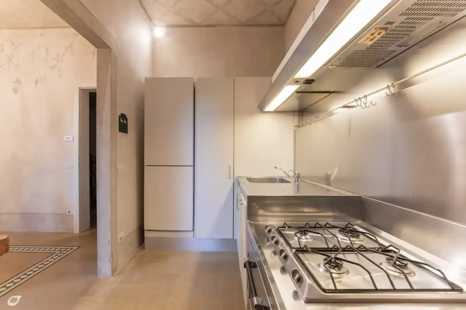Modern kitchen featuring stainless steel appliances, a gas stove, and sleek cabinetry in a minimalist design. The space is well-lit with natural light and has a clean, contemporary aesthetic. | Only on SopranoVillas