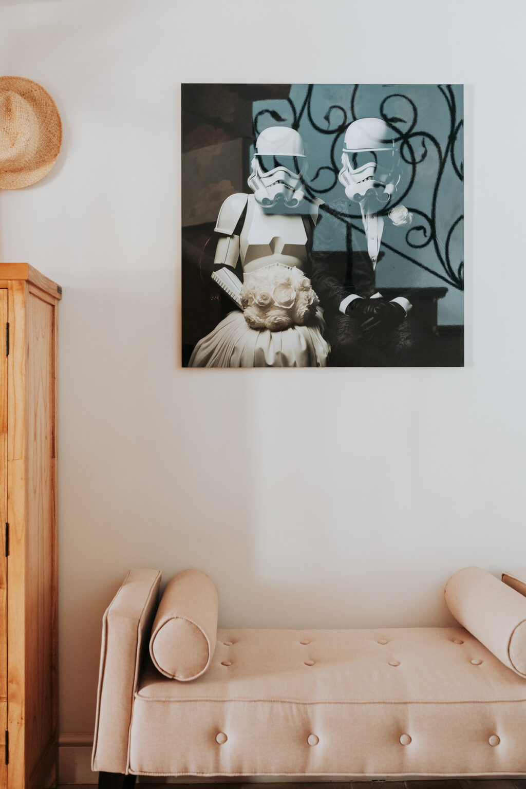 Black and white vintage photograph of a couple dressed in formal attire, featuring a woman in a light-colored dress with a floral accent and a man in a suit, displayed on a wall above a wooden cabinet. | Only on SopranoVillas