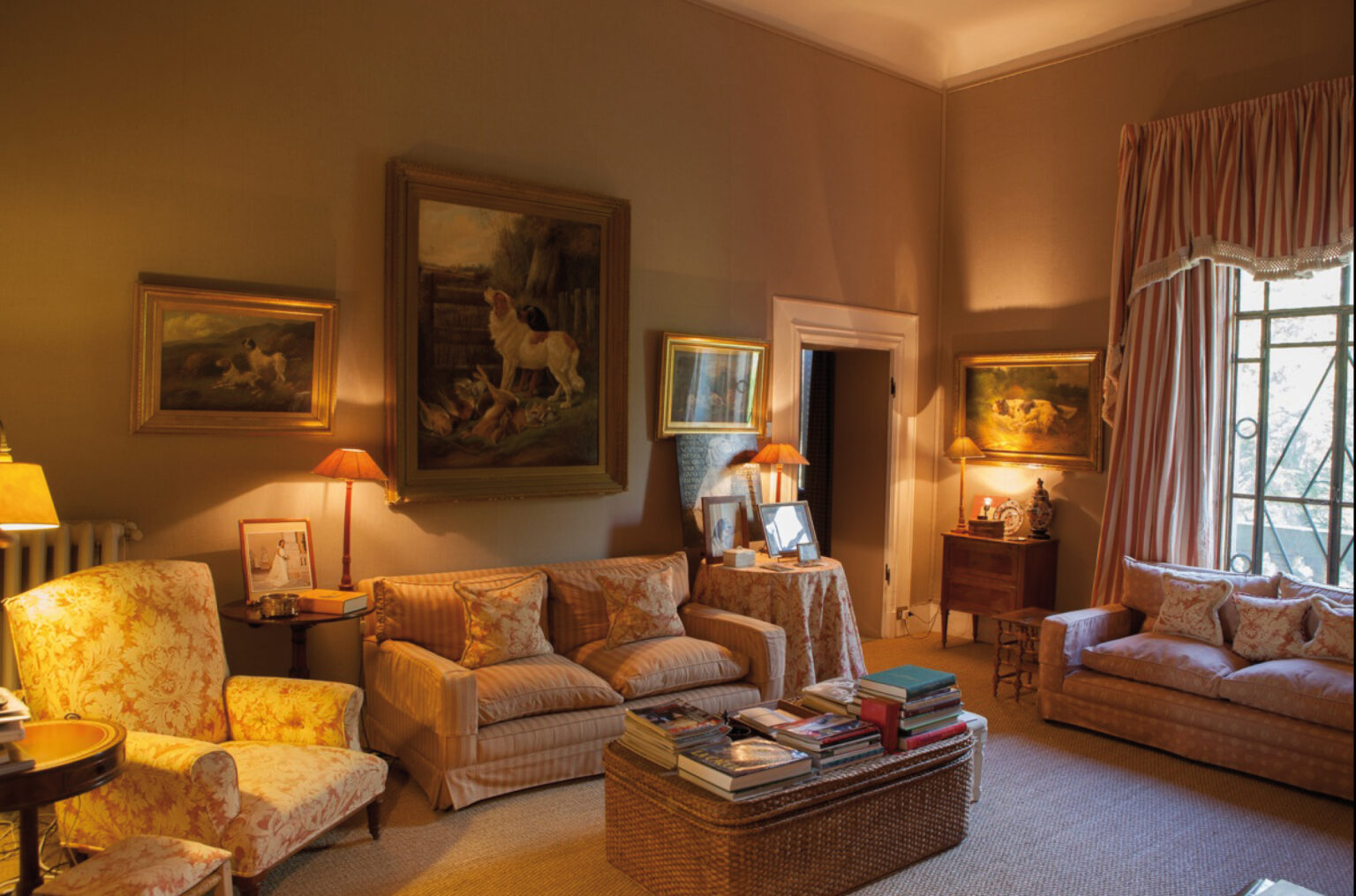 Cozy living room featuring elegant vintage furniture, warm lighting, and framed paintings on the walls, creating a welcoming atmosphere. | Only on SopranoVillas