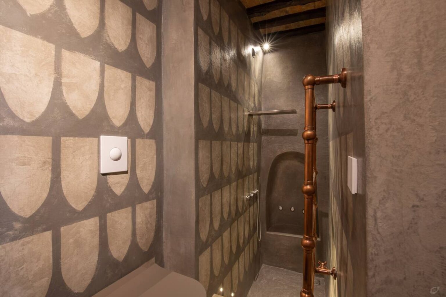 Modern bathroom interior featuring textured wall design with a unique pattern, a stylish shower area with copper fixtures, and minimalist decor. | Only on SopranoVillas