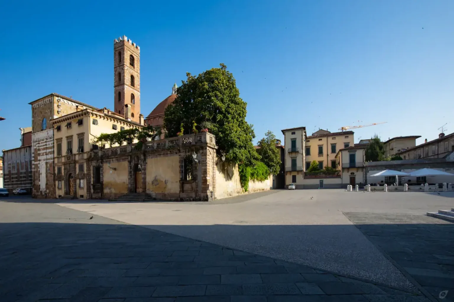 Historic square featuring a prominent bell tower and surrounding architecture, with a clear blue sky and a tranquil atmosphere. Ideal for exploring cultural landmarks and enjoying outdoor spaces. | Only on SopranoVillas