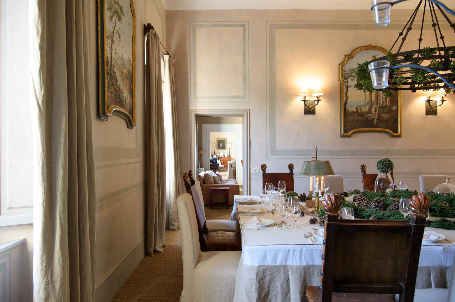 Elegant dining room featuring a beautifully set table with fine china, surrounded by tasteful decor and artwork. Natural light floods the space, highlighting the sophisticated ambiance and inviting atmosphere. | Only on SopranoVillas
