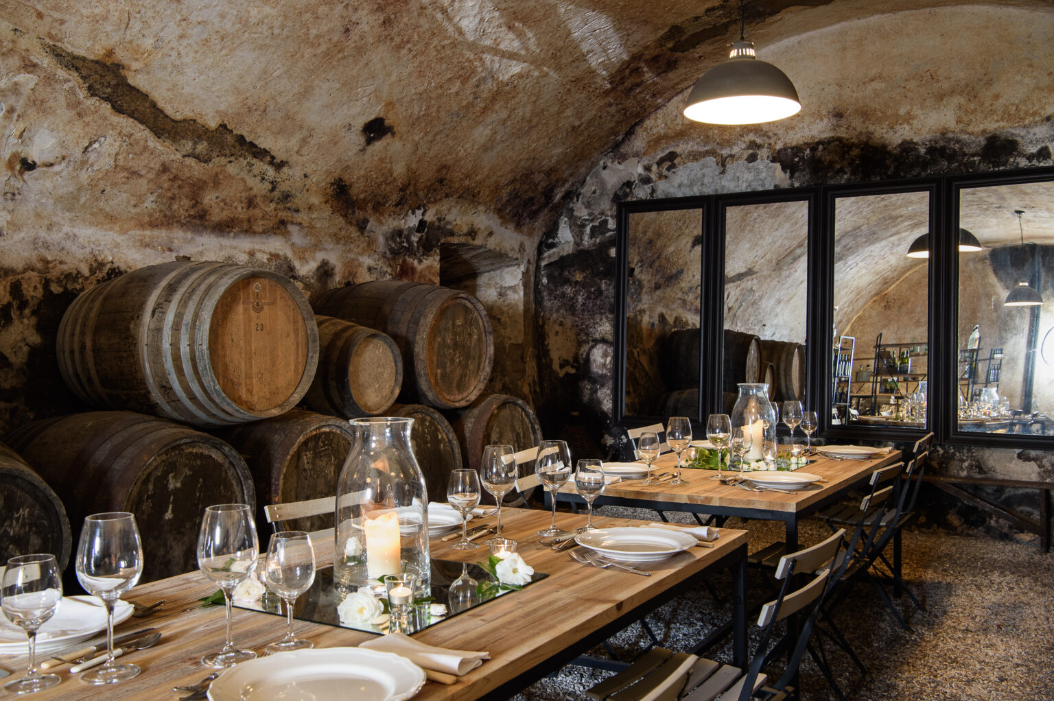 Rustic dining room in a wine cellar featuring wooden barrels, elegant table settings, and soft lighting, ideal for intimate gatherings or wine tastings. | Only on SopranoVillas