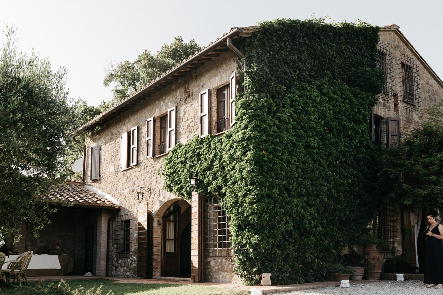 Stone house covered in ivy with wooden shutters, surrounded by greenery, set in a tranquil outdoor environment. Ideal for rustic charm and nature-inspired architecture. | Only on SopranoVillas