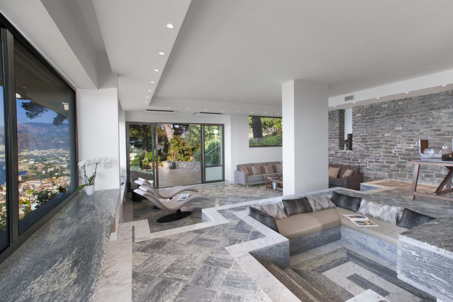 Modern luxury living room showcasing elegant marble flooring, large windows with stunning views, and stylish furniture. The open layout emphasizes natural light and contemporary design elements, creating a serene ambiance. | Only on SopranoVillas