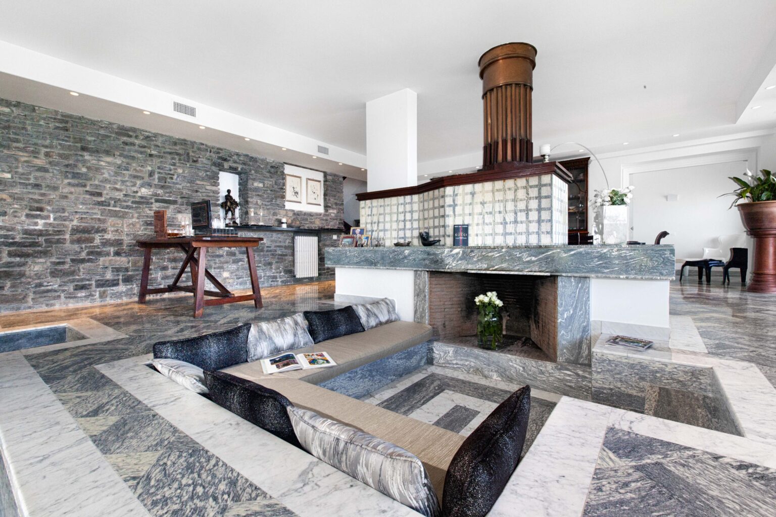 Modern interior of a luxurious hotel lobby featuring elegant stone flooring, a stylish reception area, and contemporary furnishings, creating a welcoming atmosphere for guests. | Only on SopranoVillas