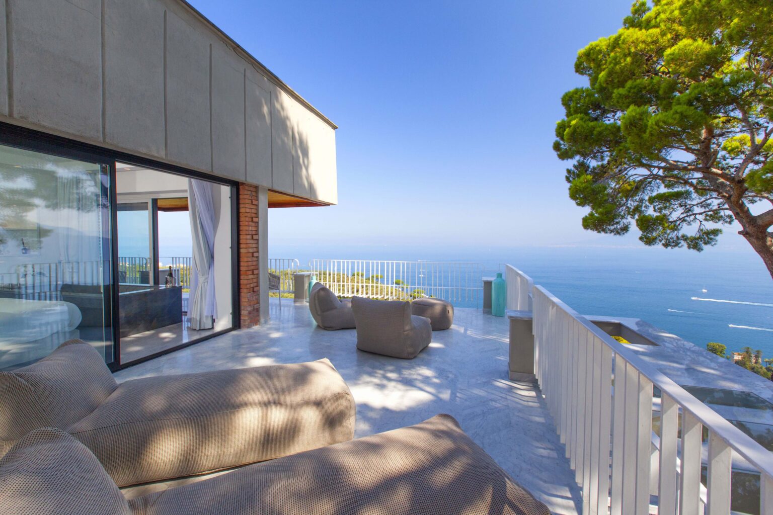 Modern ocean-view terrace with comfortable seating, featuring a sleek design and lush greenery, perfect for relaxation and entertaining. | Only on SopranoVillas