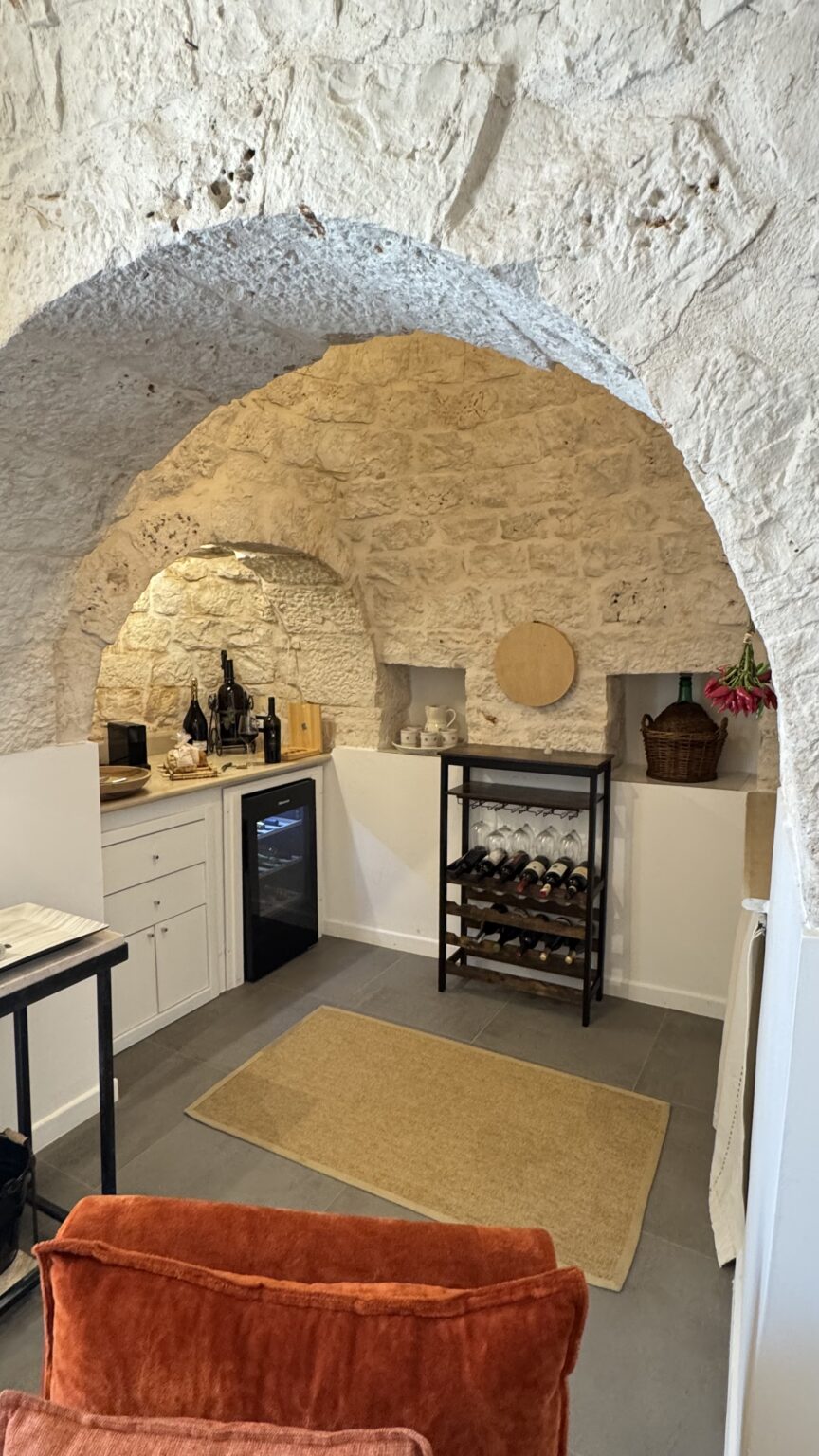 Cozy kitchen with stone walls featuring a wine rack, modern refrigerator, and wooden accents, ideal for entertaining and culinary activities. | Only on SopranoVillas