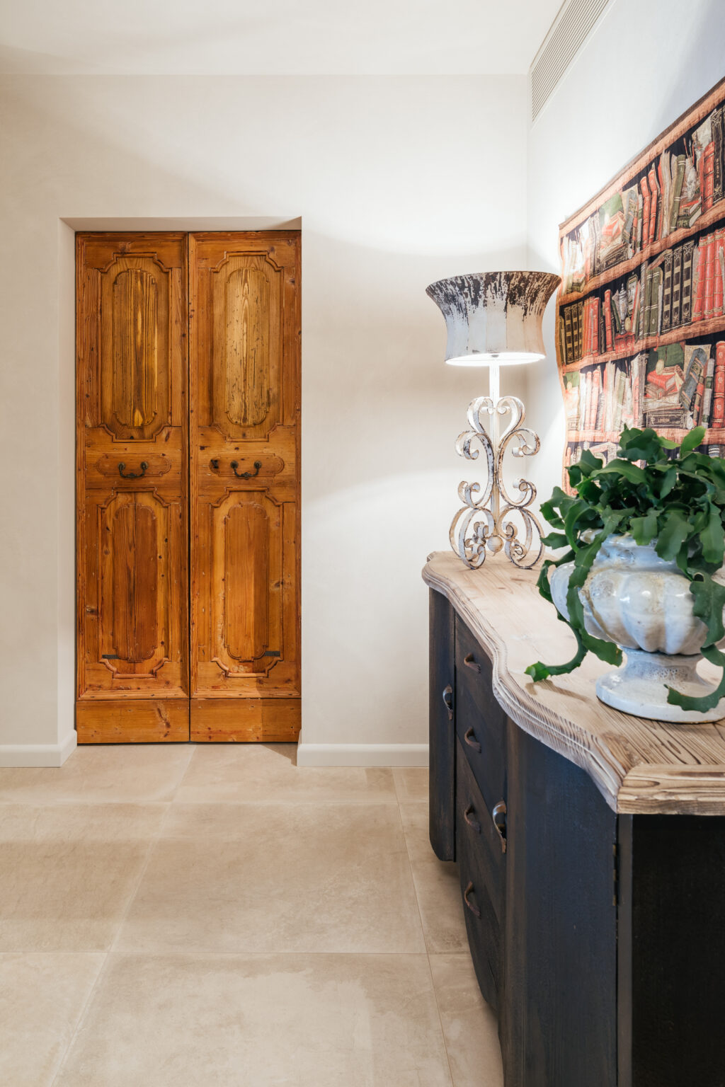Rustic wooden double doors in a stylish entryway, accompanied by an elegant lamp and a decorative plant in a ceramic pot, showcasing a blend of modern and traditional design elements. | Only on SopranoVillas
