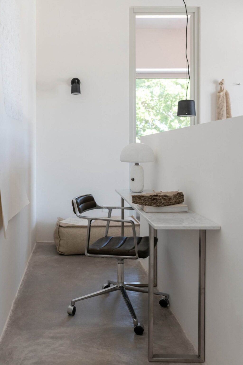 Modern interior design featuring a minimalist workspace with a sleek marble table, a stylish chair, and a contemporary lamp, set against a bright white wall. | Only on SopranoVillas