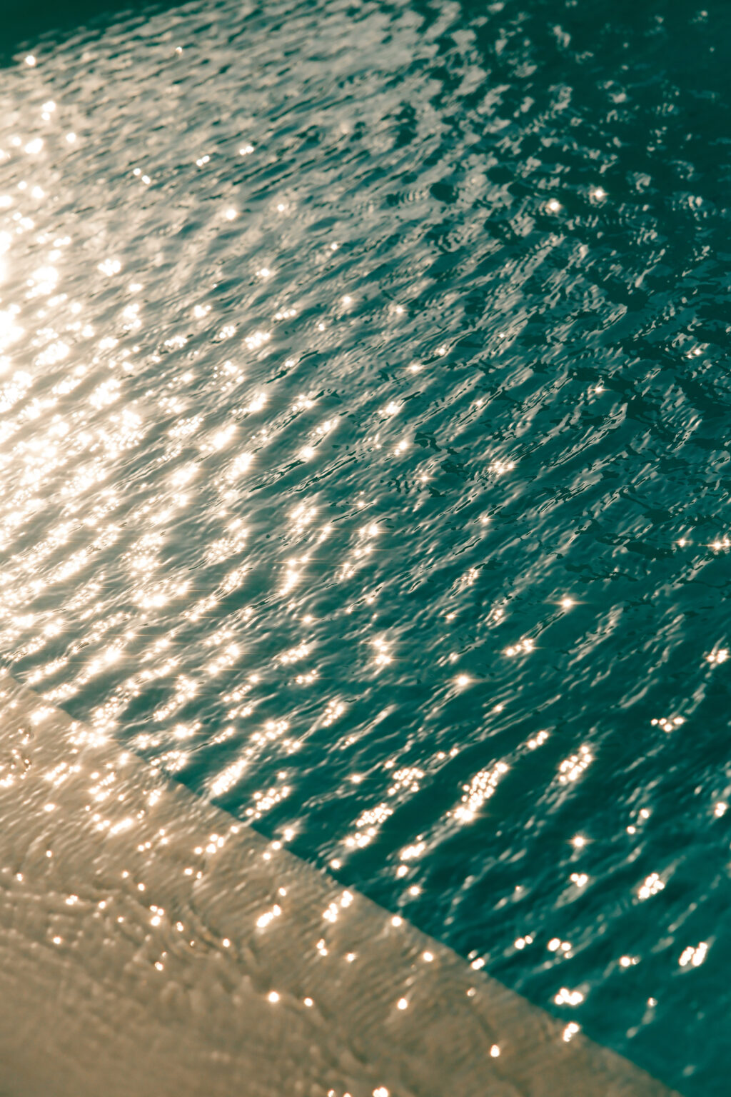 Sunlight reflecting on rippling turquoise water, creating a shimmering effect. | Only on SopranoVillas