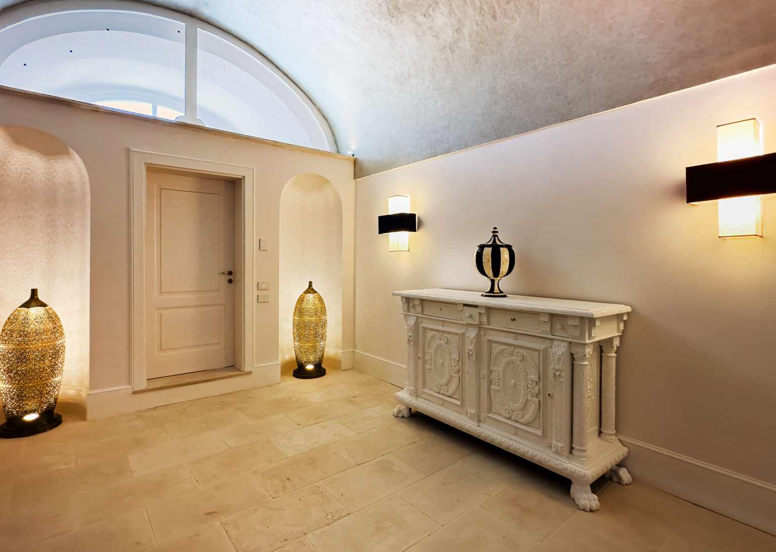 Elegant hallway featuring a white ornate console table, decorative lamps, and an arched ceiling, creating a sophisticated entryway ambiance. | Only on SopranoVillas