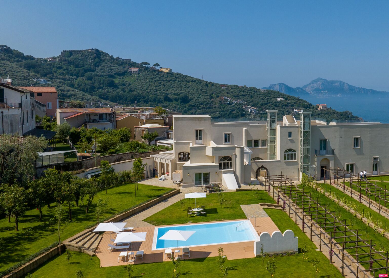 Luxury villa with a swimming pool, surrounded by lush greenery and mountains, overlooking the sea. Ideal for relaxation and scenic views in a Mediterranean setting. | Only on SopranoVillas
