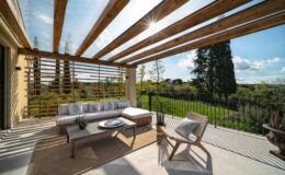 Modern outdoor patio with wooden beams, comfortable seating, and a scenic view of lush greenery. Ideal for relaxation and entertaining. Natural light enhances the inviting atmosphere.