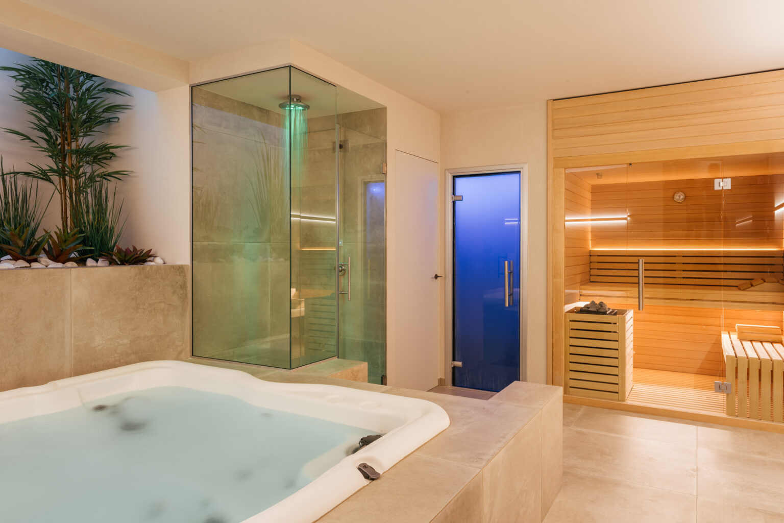 Luxurious spa interior featuring a modern hot tub, glass shower, and a wooden sauna, surrounded by greenery for a relaxing atmosphere. | Only on SopranoVillas