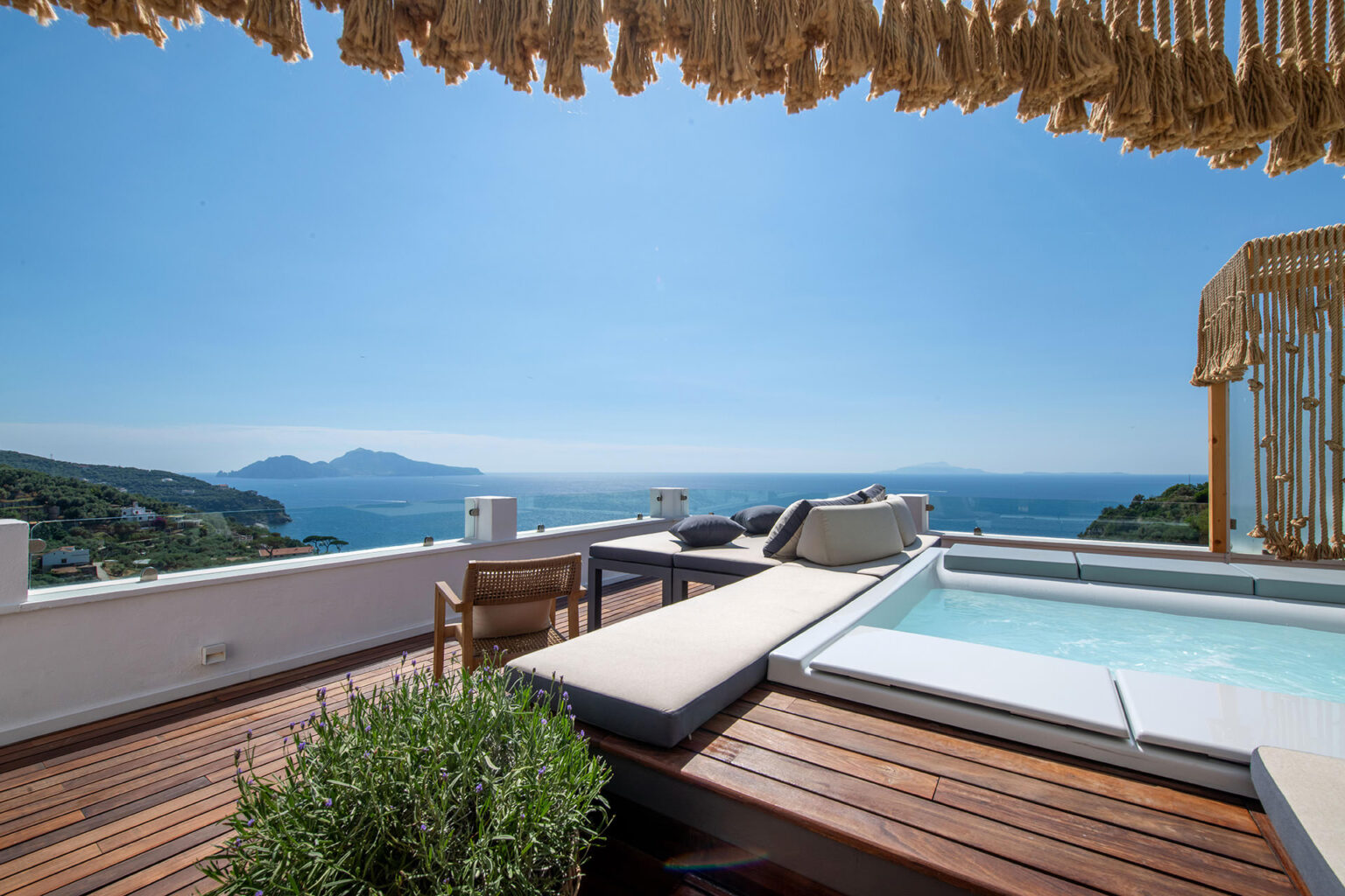Luxurious outdoor terrace with a private hot tub, wooden deck, and stunning ocean views, ideal for relaxation and leisure. | Only on SopranoVillas
