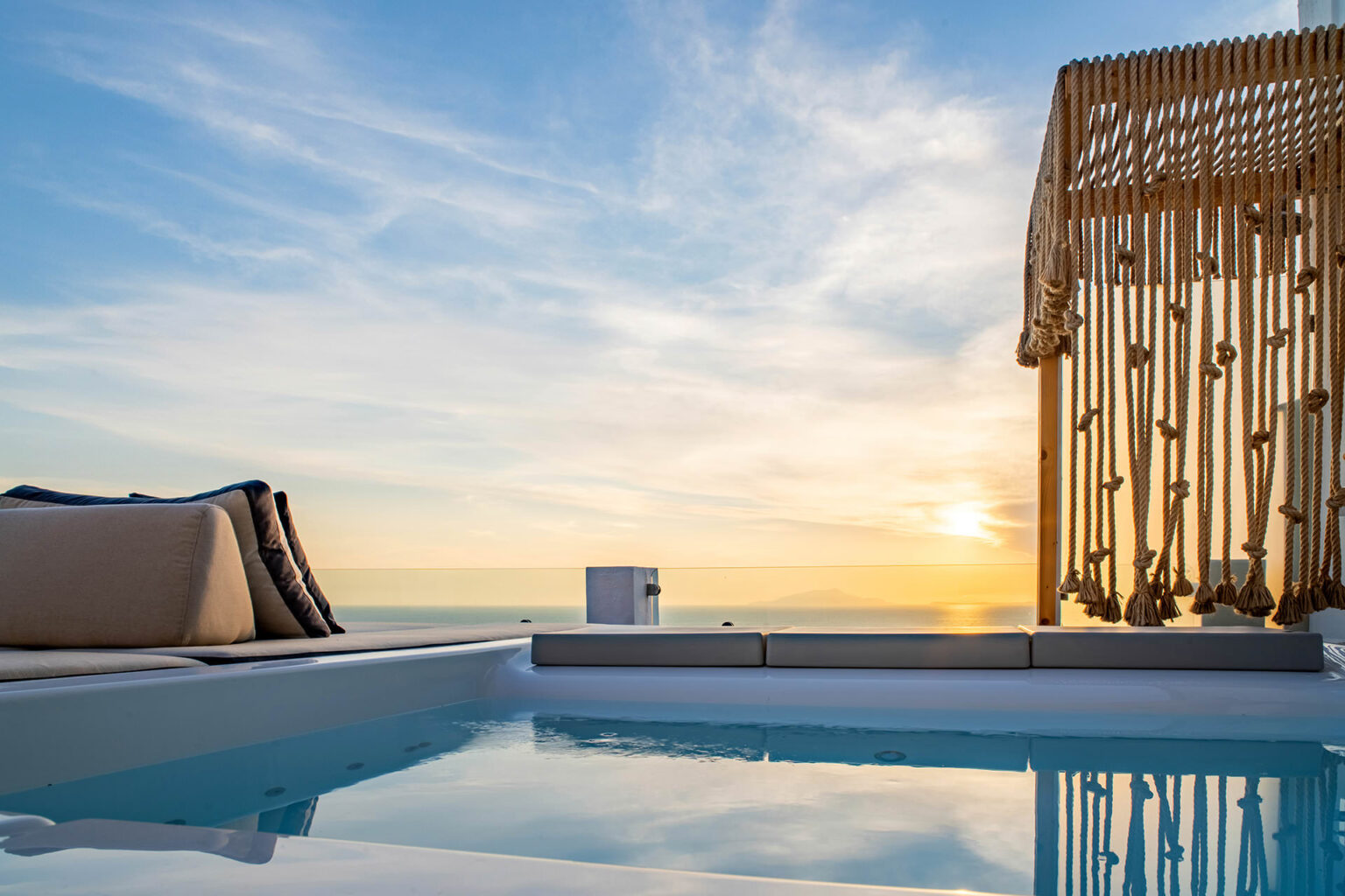 Luxury rooftop pool with sunset view, featuring comfortable lounge seating and a wooden pergola, creating a serene and inviting atmosphere. | Only on SopranoVillas