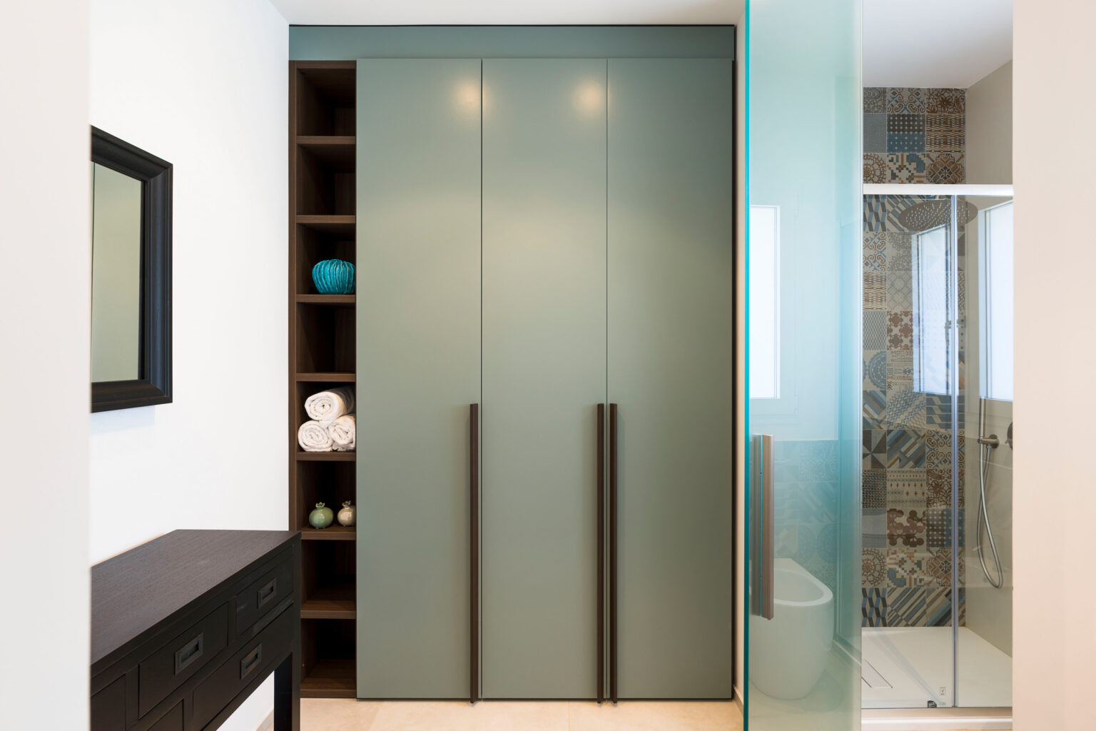 Modern bathroom design featuring sleek glass shower, minimalist cabinetry, and stylish storage shelves with decorative items. | Only on SopranoVillas