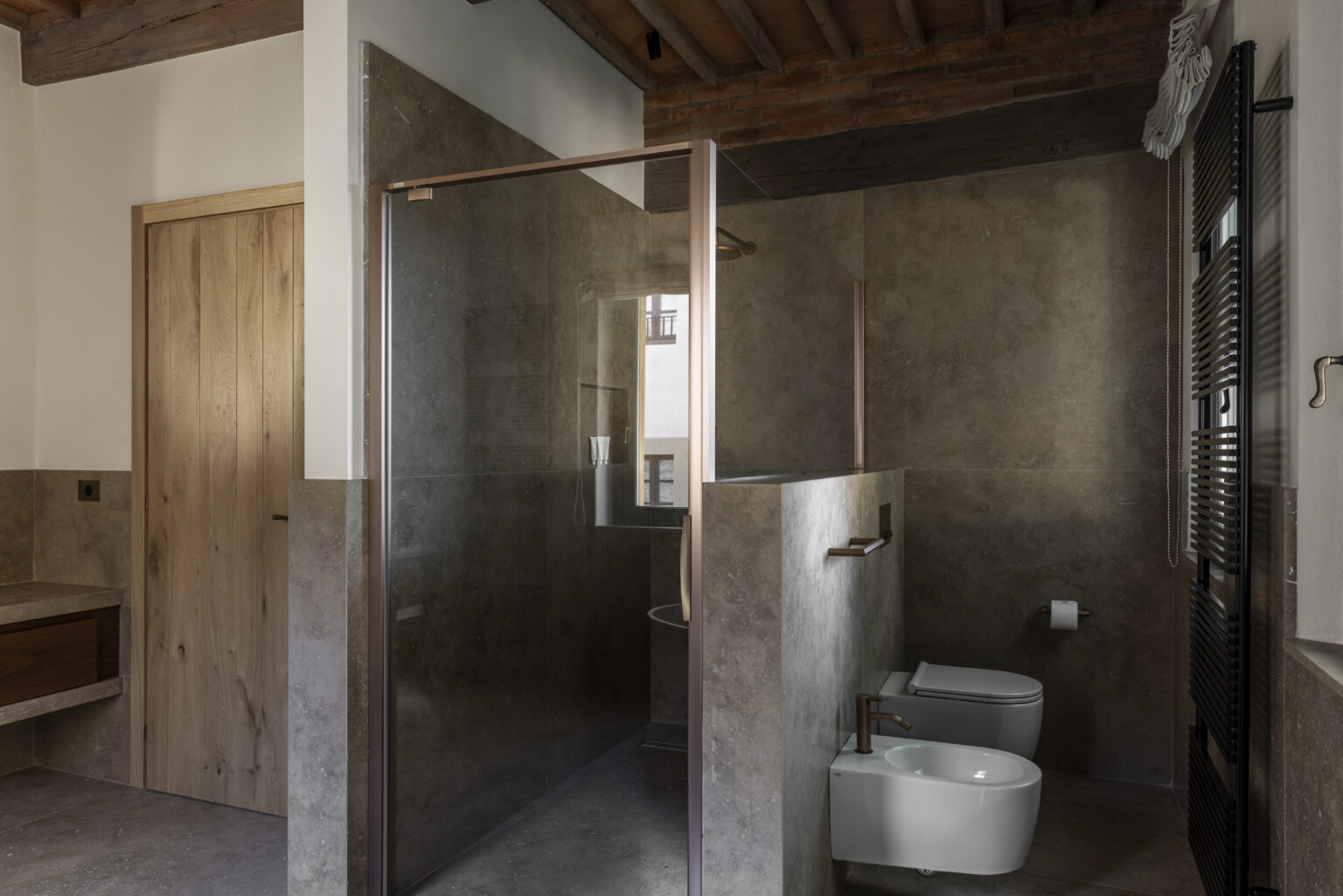 Modern bathroom featuring a glass shower enclosure, sleek toilet, and minimalist design elements, with wooden accents and neutral color scheme. | Only on SopranoVillas