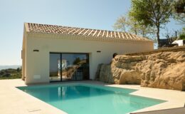 Modern villa with a private swimming pool, featuring a minimalist design and natural stone accents, surrounded by lush greenery and scenic views. Ideal for luxury retreats and vacation getaways.