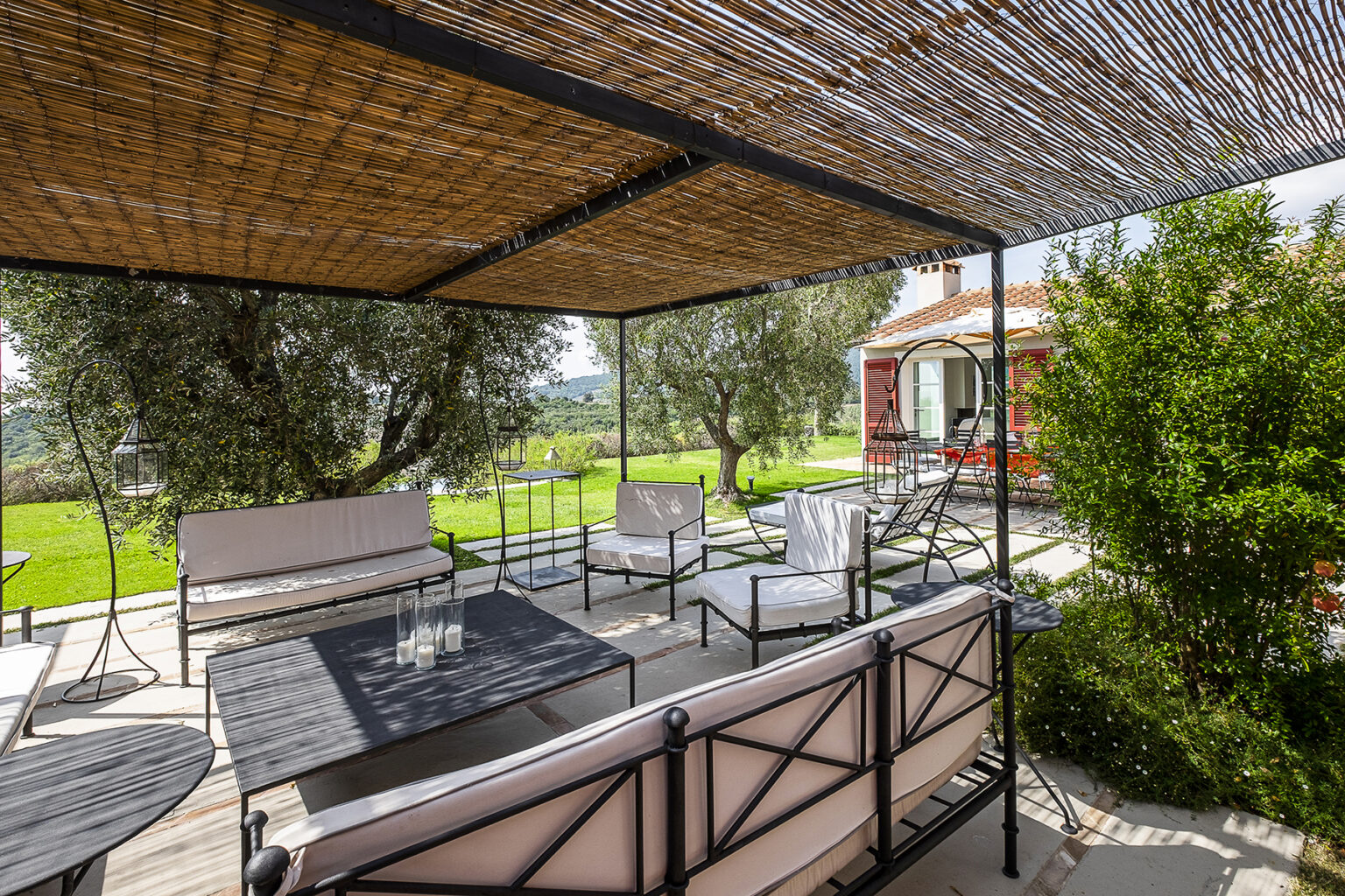 Outdoor lounge area featuring comfortable seating under a bamboo canopy, surrounded by greenery and a scenic landscape. Ideal for relaxation and entertaining guests. | Only on SopranoVillas