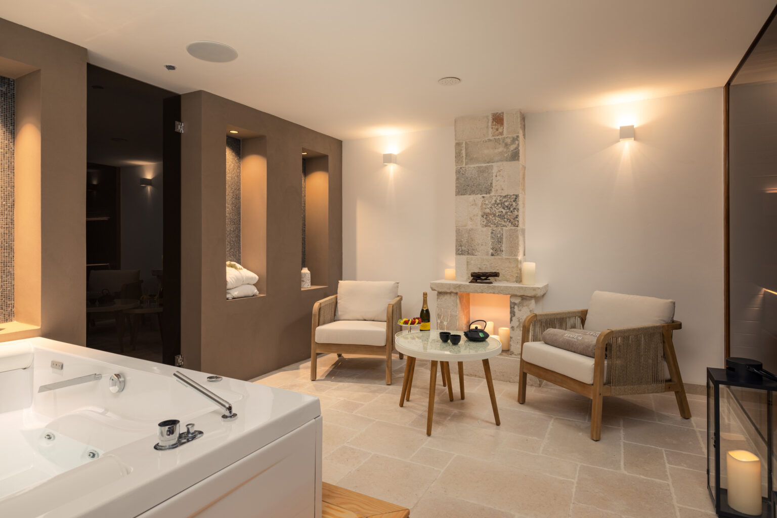 Spa relaxation room featuring a hot tub, two comfortable chairs, a small table with drinks, and ambient lighting for a tranquil atmosphere. | Only on SopranoVillas