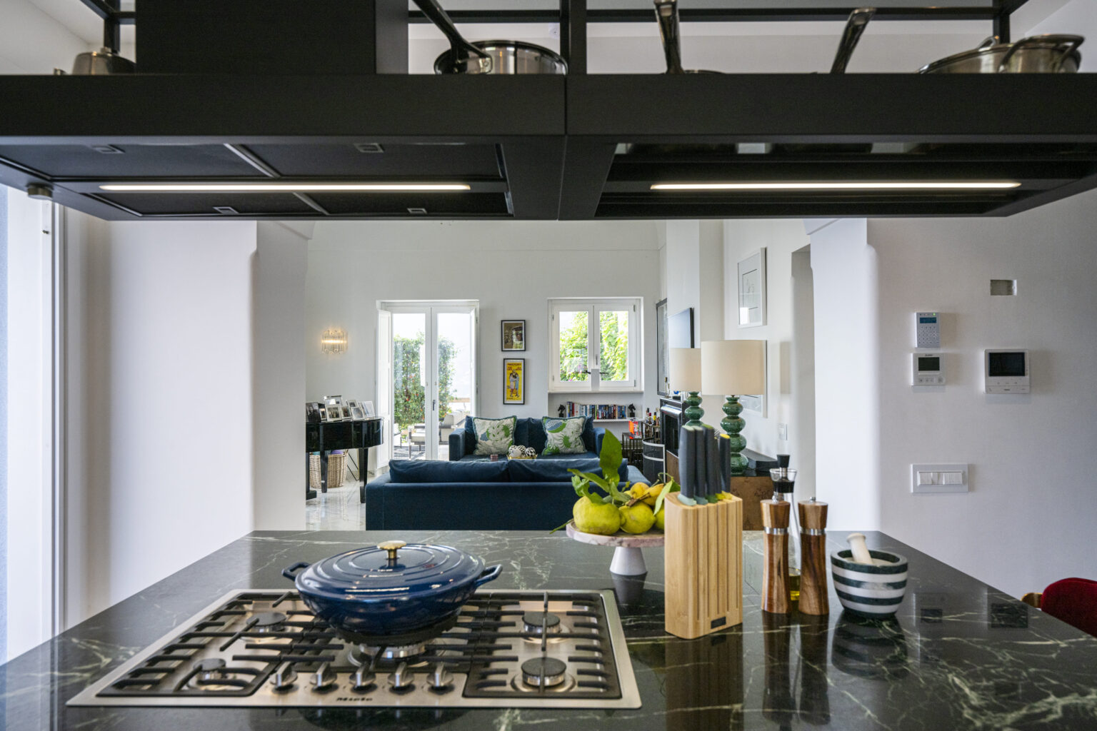 Luxury villa kitchen with modern appliances and elegant decor, showcasing a spacious living area in the background, perfect for vacation rentals in Italy. | Only on SopranoVillas