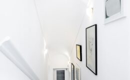 Elegant staircase in a luxury villa for rent in Italy, featuring modern artwork and soft lighting, showcasing the villa's sophisticated interior design.