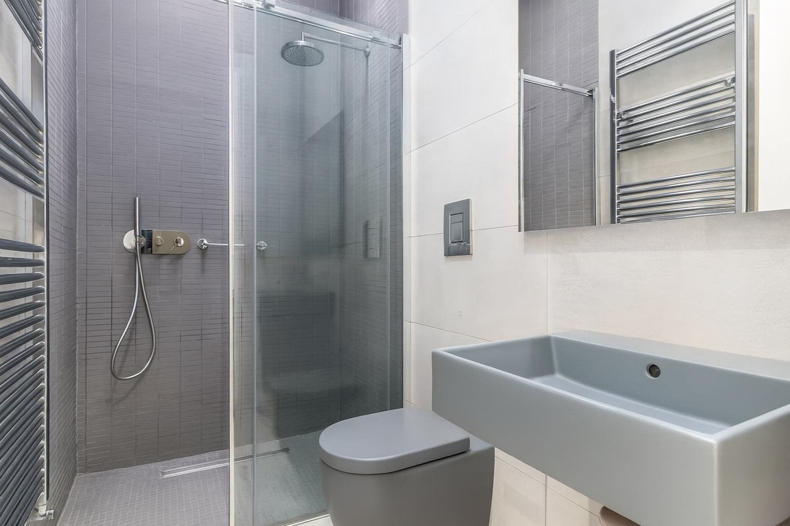 Modern bathroom featuring a glass shower enclosure, sleek gray sink, and stylish heated towel rack, designed for a contemporary aesthetic. | Only on SopranoVillas