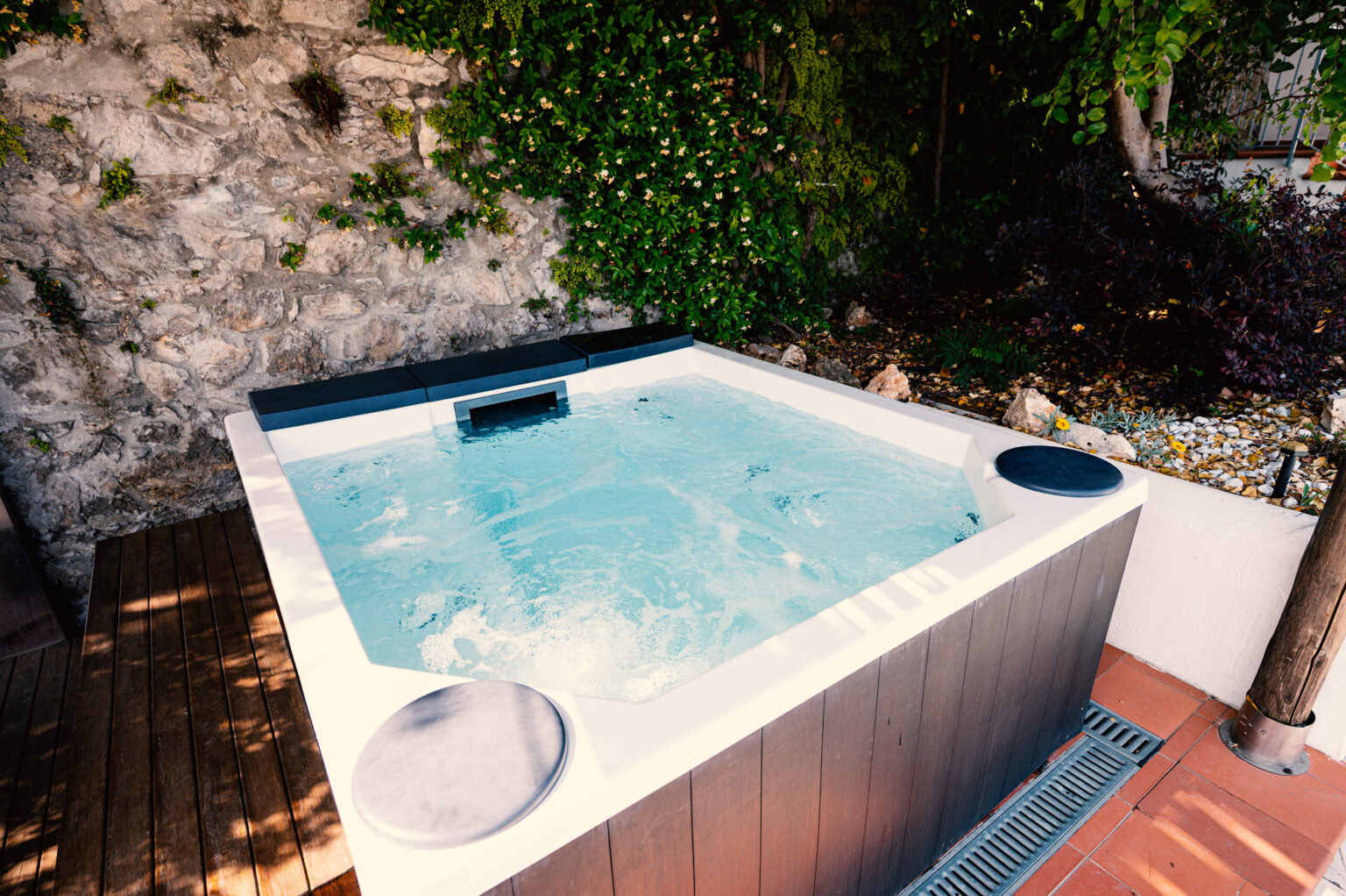 Luxury villa rental in Italy featuring a private outdoor hot tub surrounded by lush greenery, perfect for relaxation and leisure. | Only on SopranoVillas