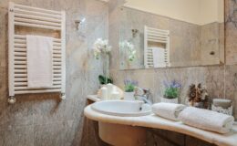 Luxury villa bathroom in Italy featuring elegant marble finishes, a stylish sink, fresh flowers, and plush towels, perfect for a relaxing getaway.