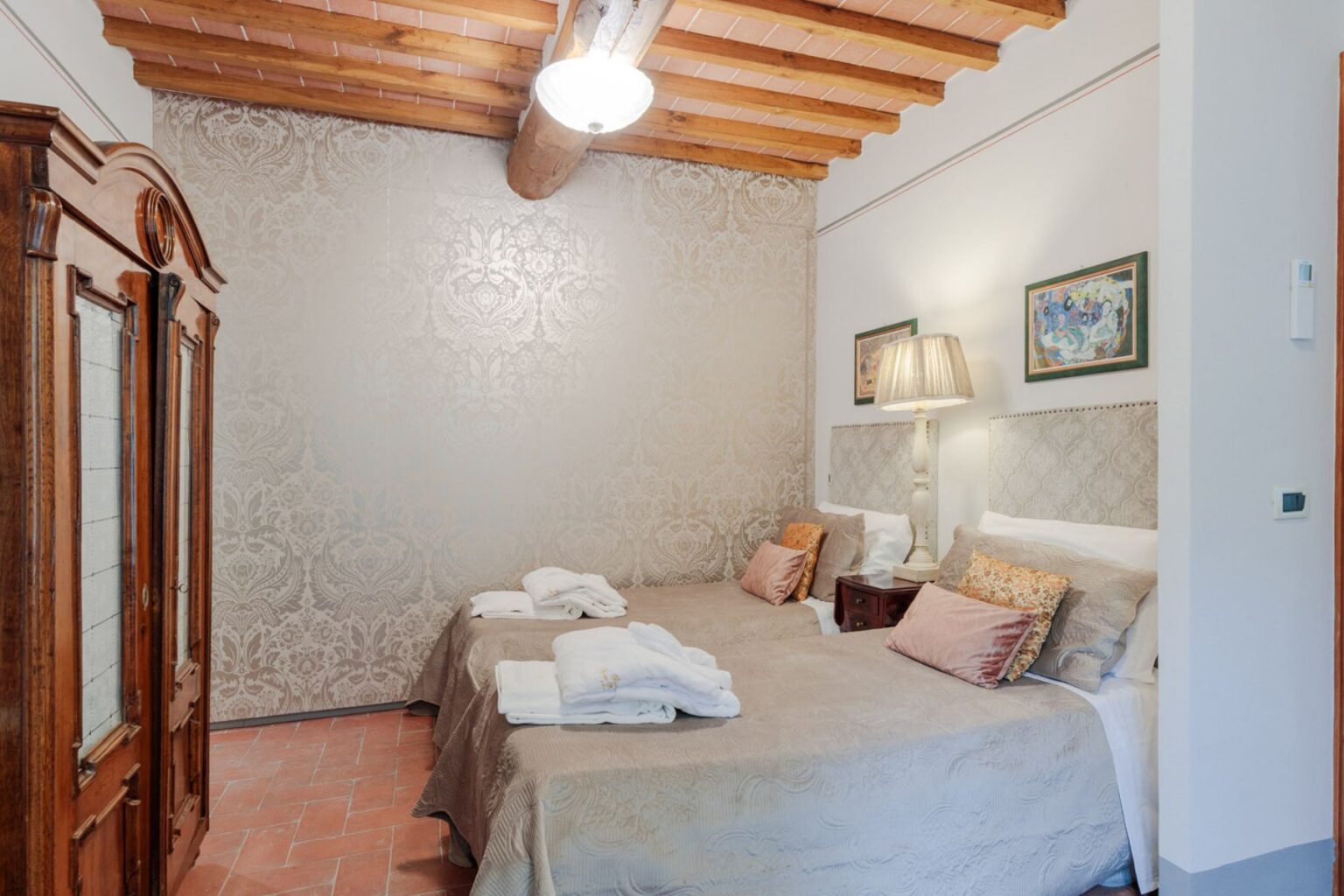 Cozy bedroom with two twin beds, wooden beams, and elegant decor, featuring a vintage wardrobe and soft lighting, ideal for relaxation and comfort. | Only on SopranoVillas
