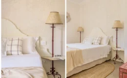 Cozy bedroom featuring a light-colored headboard, elegant pillows, and stylish bedside lamps. The room is adorned with textured wallpaper and a round jute rug, creating a warm and inviting atmosphere. A small wooden table holds a pair of glasses and a book, enhancing the tranquil setting.