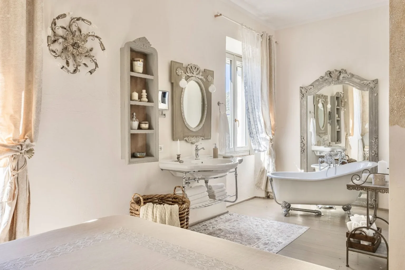 Elegant bathroom featuring a vintage clawfoot bathtub, ornate mirror, and stylish sink. Soft neutral tones and natural light enhance the serene atmosphere, complemented by decorative shelving and a cozy woven basket with towels. Ideal for relaxation and aesthetic inspiration. | Only on SopranoVillas